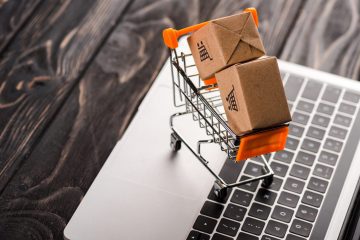 toy boxes in small shopping cart on laptop e-commerce